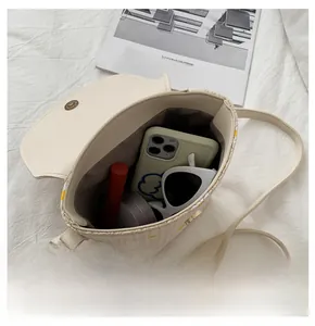 Vista interna della borsa a tracolla intrecciata beige con spazio per telefono e trucco