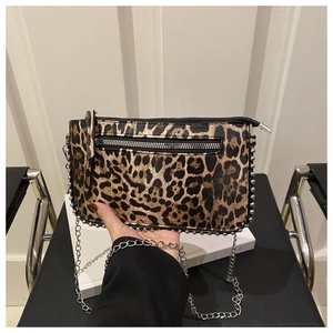 Detail of leopard print crossbody bag featuring silver studs and metal chain strap