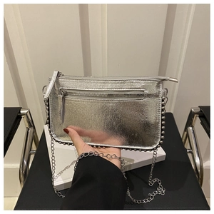 Detail of silver metallic crossbody bag with beaded trim and sleek chain strap