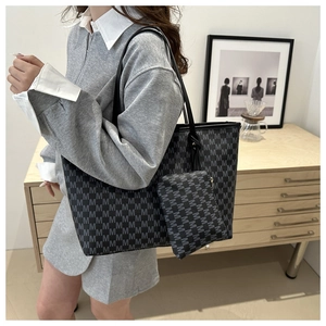Detail of black tote bag set with M-letter pattern and matching small zipper pouch