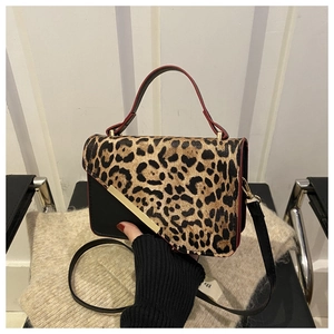Détail du sac bandoulière léopard avec garniture dorée et bandoulière en cuir noir