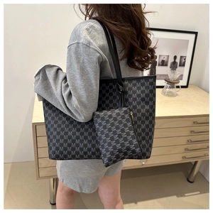 Detailed lifestyle view of large tote bag with M-pattern monogram and inner pouch set