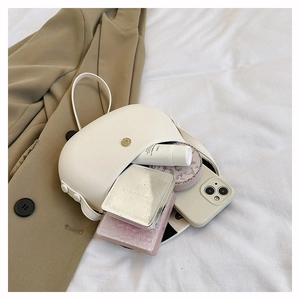 Detail of minimalist cream saddle bag interior capacity with golden buckle on fabric