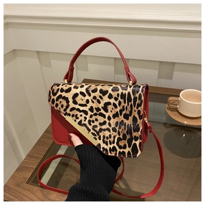 Détail du sac à main en cuir PU rouge avec rabat léopard et garniture dorée