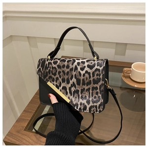 Détail du sac à bandoulière léopard avec fermoir doré rectangulaire et poignée en cuir