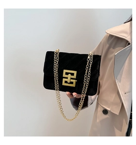 Détail du sac bandoulière en velours noir avec fermoir métallique doré et chaîne élégante
