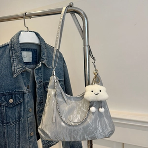Silver metallic pleated shoulder tote bag with a white cloud pendant on a hanger