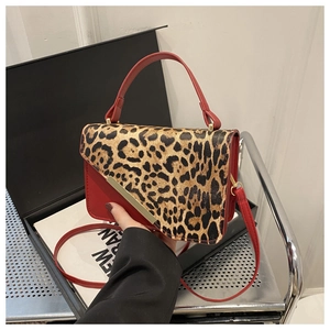 Détail du sac rouge avec rabat à motif léopard et garniture en métal doré élégant