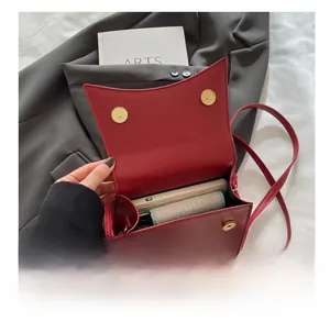 Détail de la capacité intérieure d'un sac à bandoulière en cuir rouge avec boucles aimantées