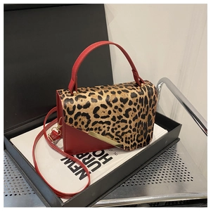 Détail du sac à bandoulière en cuir rouge et imprimé léopard avec barre en métal doré