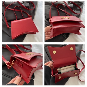 Vue détaillée du sac bandoulière rouge à nœud montrant l'intérieur et la boucle dorée