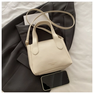 Dettaglio della borsa a secchiello in pelle martellata bianco crema con logo