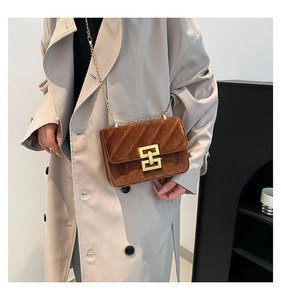 Gros plan du sac bandoulière en velours marron avec motif matelassé et détails dorés