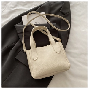 Dettaglio borsa tote in pelle grana litchi color panna con manico e tracolla sottile