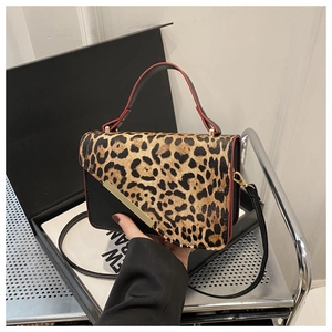 Détail du sac léopard avec bordures rouges et finitions métalliques dorées