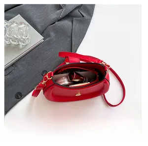 Interior view of red crescent bag showing storage capacity for cosmetics and gold hardware