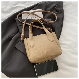 Mini borsa a secchiello in pelle martellata beige con smartphone per scala su blazer