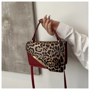 Détail du sac bandoulière rouge avec rabat léopard et garniture en métal doré