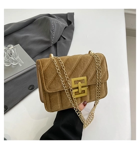Détail du sac bandoulière en velours beige avec matelassage en V et fermoir carré doré