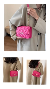 Detail of fuchsia geometric quilted crossbody bag with gold chain strap and metal clasp