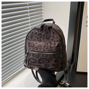 Detail eines Mini-Rucksacks mit Leopardenmuster, Samttextur und kleiner Schleife