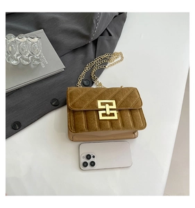 Détail d'un sac bandoulière en velours jaune avec fermoir doré et téléphone de référence