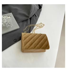 Détail du velours matelassé et de la bandoulière en chaîne dorée du petit sac carré