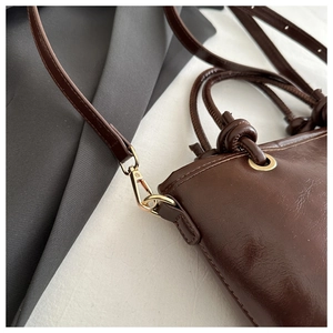 Détail d'un sac à main vintage en cuir ciré marron avec fermoirs métalliques dorés