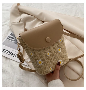 Dettaglio mini borsa a tracolla in paglia con stampa margherite e patta in pelle beige