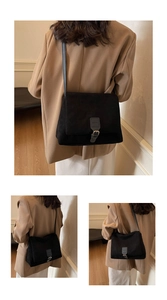 Detail of a vintage black matte suede crossbody bag styled with a beige blazer outfit