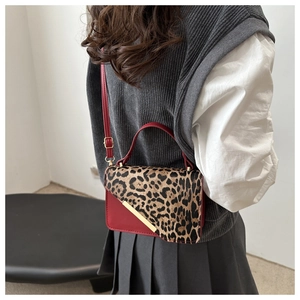 Détail du sac en cuir rouge foncé avec rabat léopard et garniture en métal doré