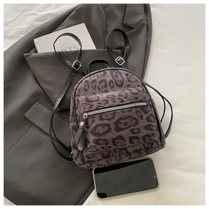 Detail eines Mini-Rucksacks mit Leopardenmuster aus lila-grauem Kunstfell auf einem Blazer