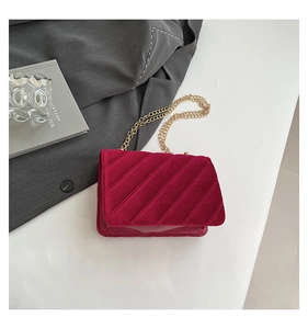 Détail du sac à bandoulière en velours fuchsia avec surpiqûres et chaîne dorée