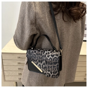 Détail du sac à rabat léopard avec garniture dorée et chaîne sur un blazer chic