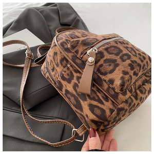 Detail des Leopard-Rucksacks mit braunem Lederriemen und Kontrastnähten als Akzent