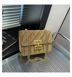 Détail de la texture en velours matelassé et fermoir doré vintage du sac chaîne