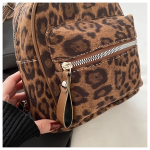 Detail eines Rucksacks mit Leopardenmuster, Metallreißverschluss und Kontrastnähten
