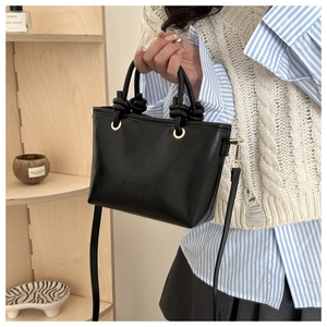 Détail du sac seau noir en cuir avec gaufrage FASHION et poignée à nœuds
