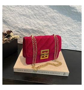 Détail du sac bandoulière en velours fuchsia avec matelassage en V et fermoir doré