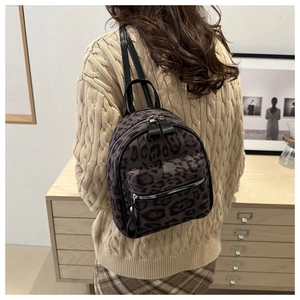 Detail eines grauen Mini-Rucksacks mit Leopardenmuster und Reißverschlüssen
