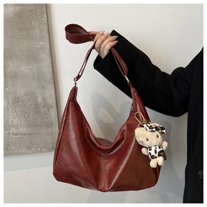 Close-up of burgundy hobo bag in faux leather with adjustable strap and contrast stitch