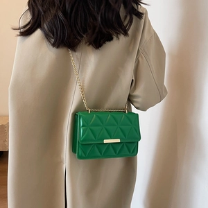 Green quilted leather crossbody bag with gold chain strap and square buckle on model