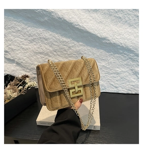 Détail du sac bandoulière en velours vintage avec matelassage en V et boucle dorée