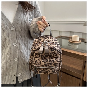 Detail eines Mini-Leoparden-Rucksacks mit braunem Ledergriff und silbernem Reißverschluss