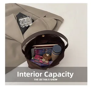 Capacité interne du sac fourre-tout marron avec tablette, carnet et objets du quotidien
