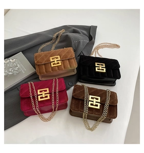 Détail de sacs bandoulière en velours avec surpiqûres verticales et chaîne dorée