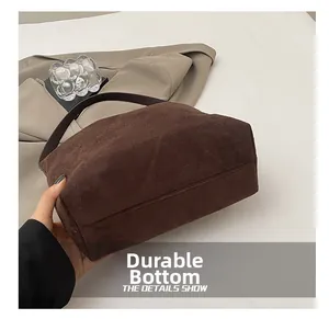 Détail de la base résistante de ce sac cabas en daim de couleur café foncé