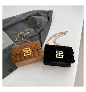 Détail de sacs bandoulière en velours marron et noir avec des chaînes dorées élégantes