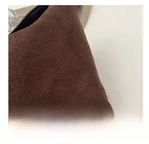 Gros plan sur la texture en daim marron foncé d'un grand sac seau vintage