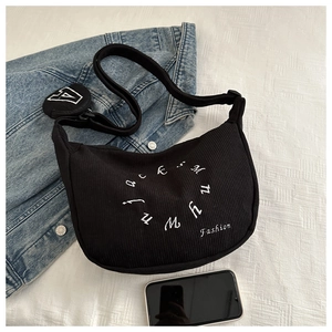 Detail of black corduroy crescent bag with letter embroidery and round coin purse